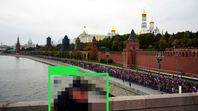 Неопознаваемый человек смотрит на Кремль с моста
