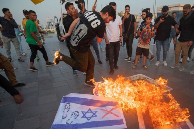 люди топчут флаг Израиля