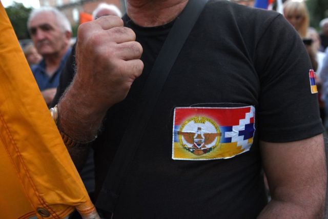 Демонстрант в Ереване с наклейкой флага Нагорно-Карабахской республики