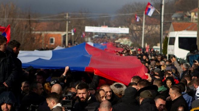 Сербские жители Митровицы в Косово несут сербский флаг