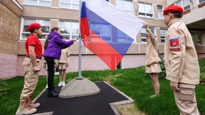 Юнармейцы поднимают российских флаг на школьном дворе