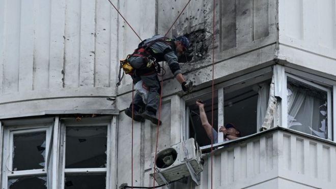 A specialist inspects the damaged facade of a multi-storey apartment building after a reported drone attack in Moscow on May 30, 2023