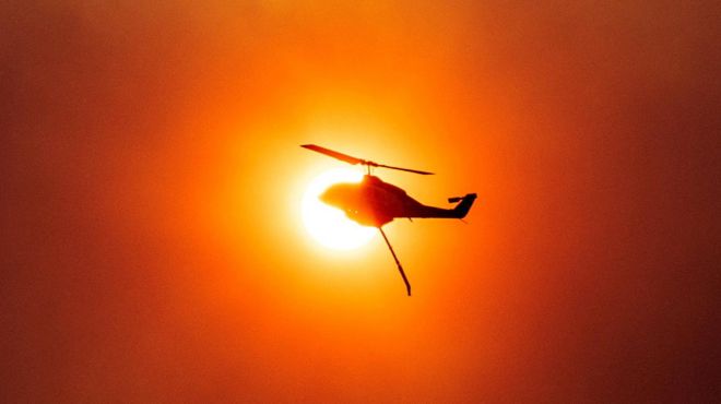 Вертолет тушит лесной пожар в Греции 18 июля 2023 года