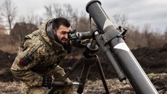 Украинский солдат смотрит в прицел миномета