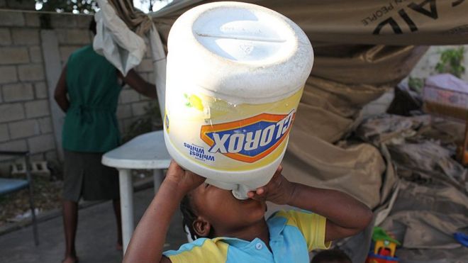 ребенок пьет воду из булытки из-под отбеливателя, Гаити, 2010 год)