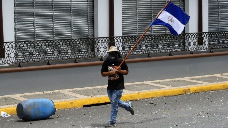A demonstrator holds a national flag during clashes with riot police in a protest against Nicaragua's President Daniel Ortega's government in Masaya, Nicaragua June 2, 2018.