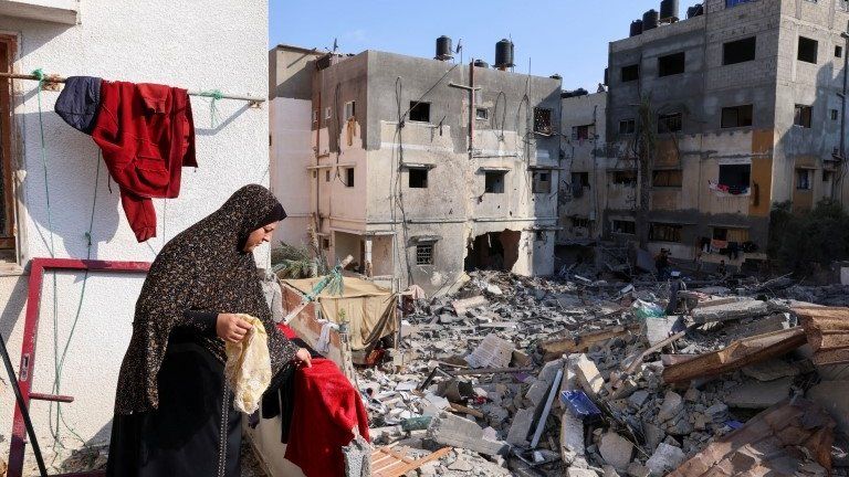 A Palestinian woman hangs laundry at her house that was damaged during Israel-Gaza fighting, as ceasefire holds, in Gaza City August 8, 2022.