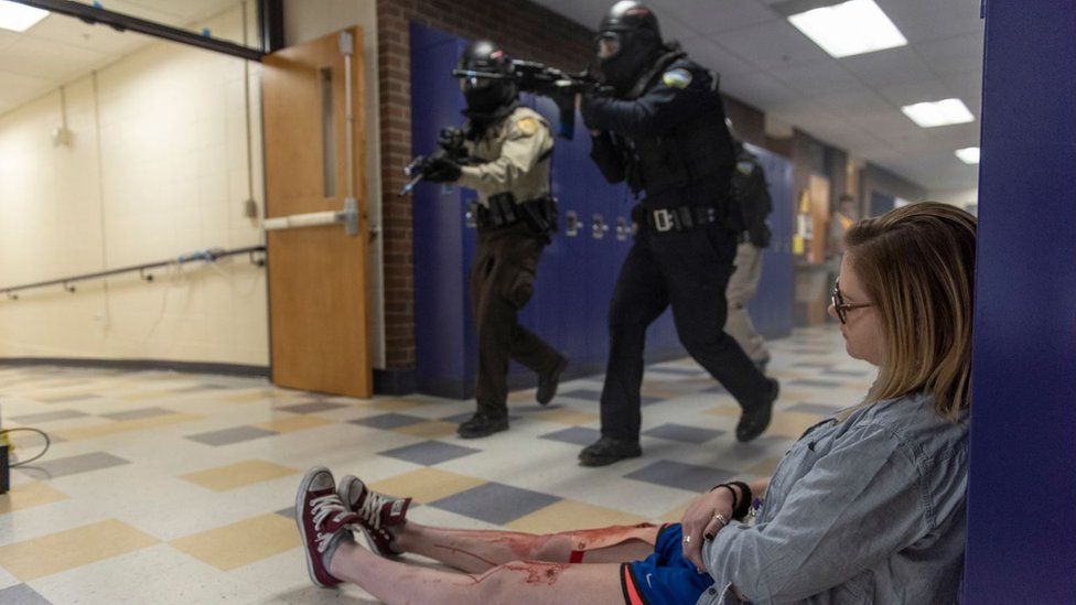 A student with fake blood on their legs slumped on the floor during an active shooter drill in California