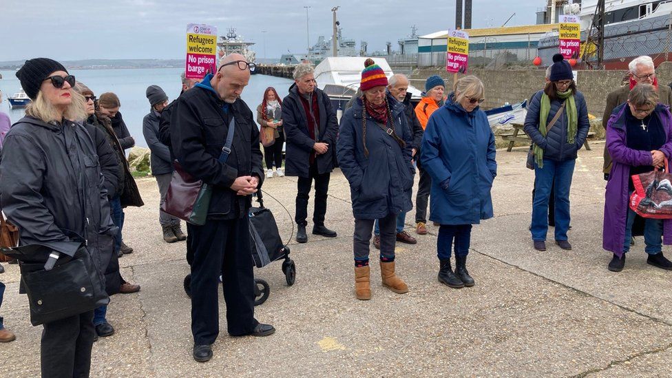 People standing in silence at Portland Port