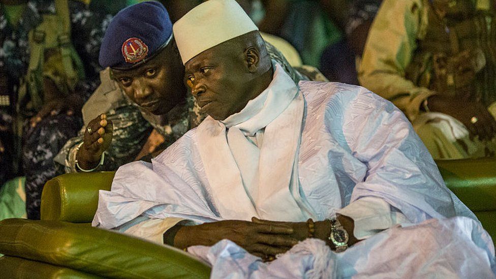Yahya Jammeh listens to one of his aides in Banjul on 29 November 2016 during an election rally in The Gambia ahead of presidential polls which the incumbent went on to lose