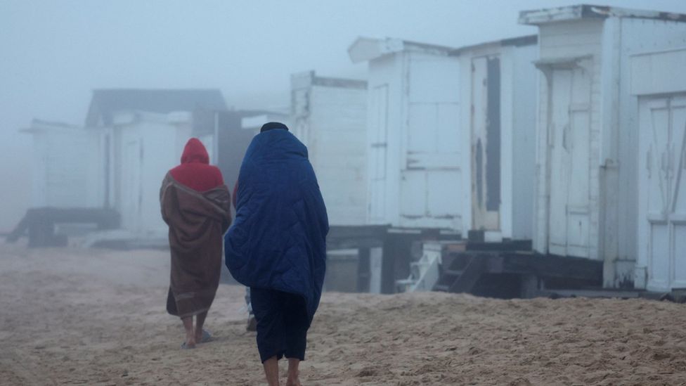 Migrants walking on a beach in Calais