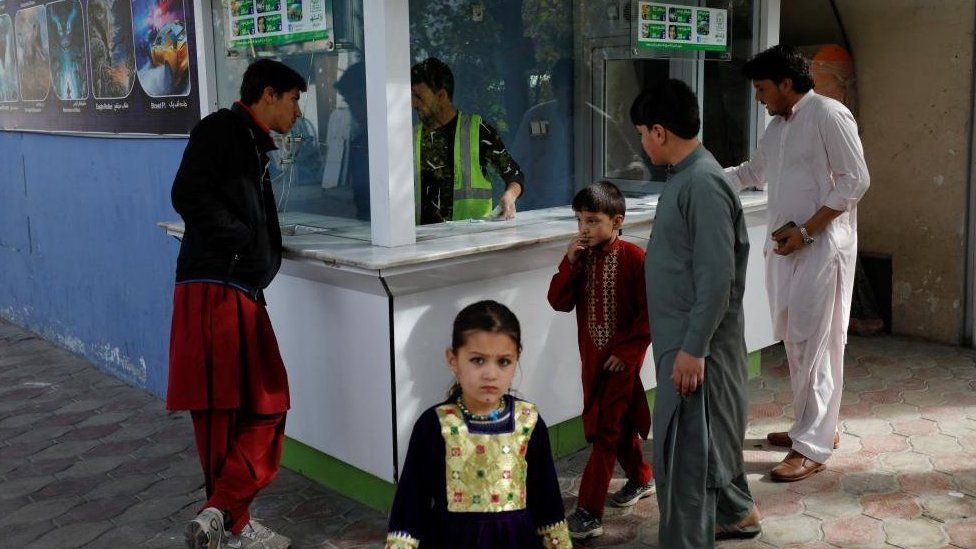 A little girl stands in front of a ticket booth in an amusement park in Kabul, Afghanistan, November 9, 2022.