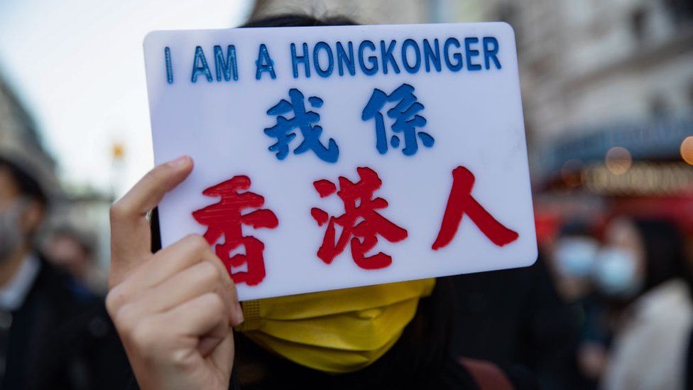 A woman holds a sign reading "I am a HongKonger"
