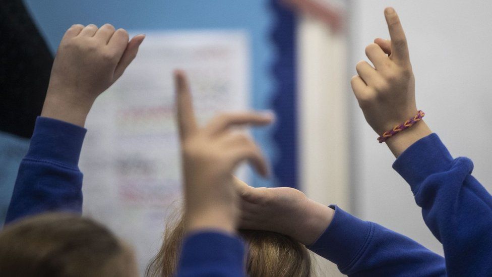 Raised hands in a classroom