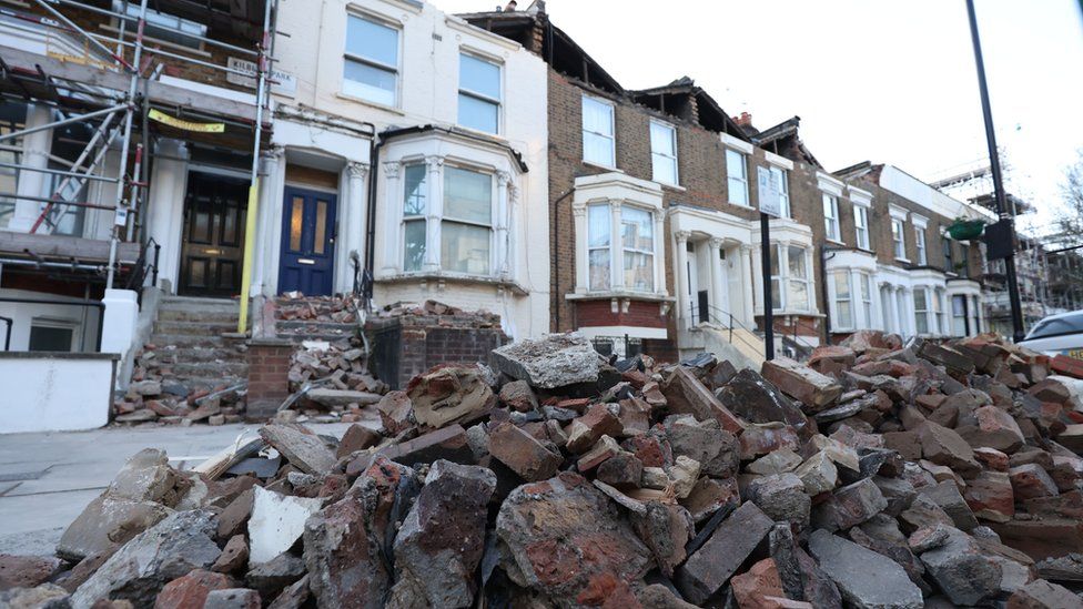 A roadside filled with debris from the rooftops of three houses which were torn off during storm Eunice, on Kilburn Park Road in north west London.