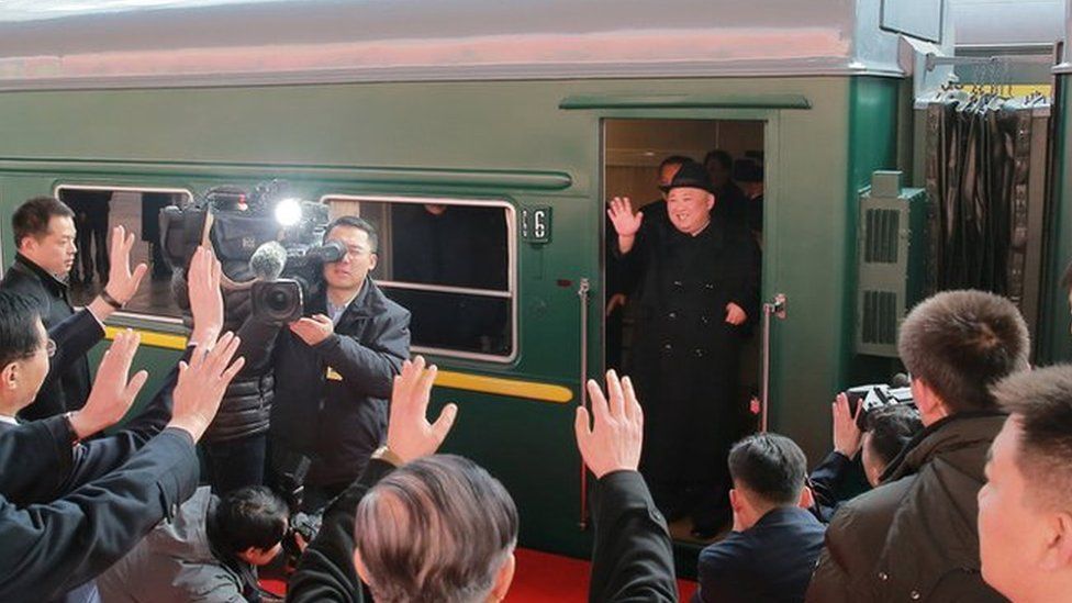 North Korean leader Kim Jong Un waves from a train in Beijing