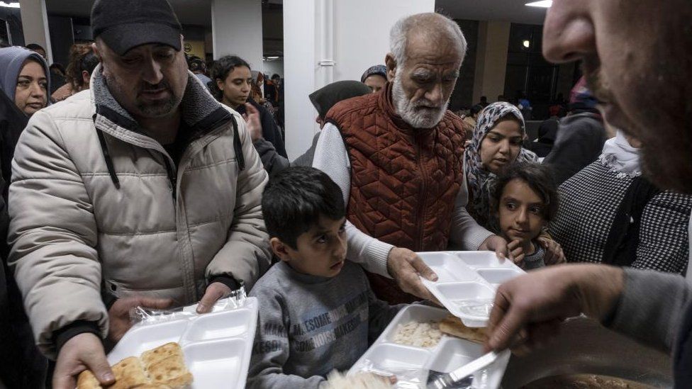People are fed at a shelter after the earthquakes