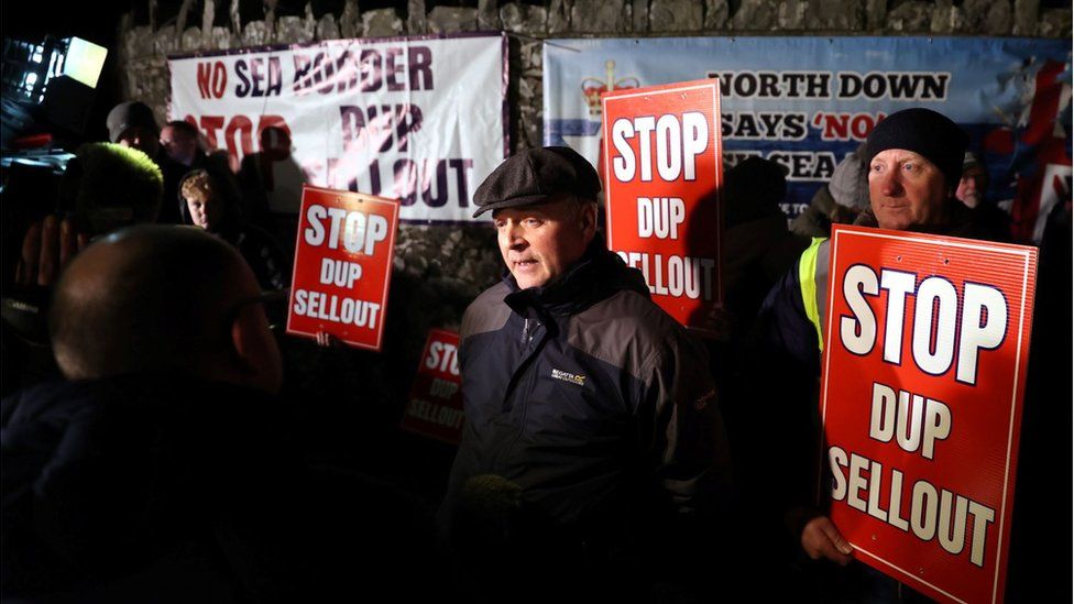 people holding signs that read Stop DUP Sellout and North Down says No to an Irish Sea Border