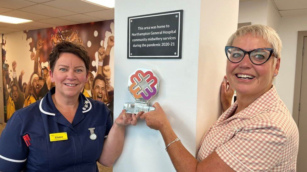 Midwives Claire Dale and Anne Richely posing with the plaque.