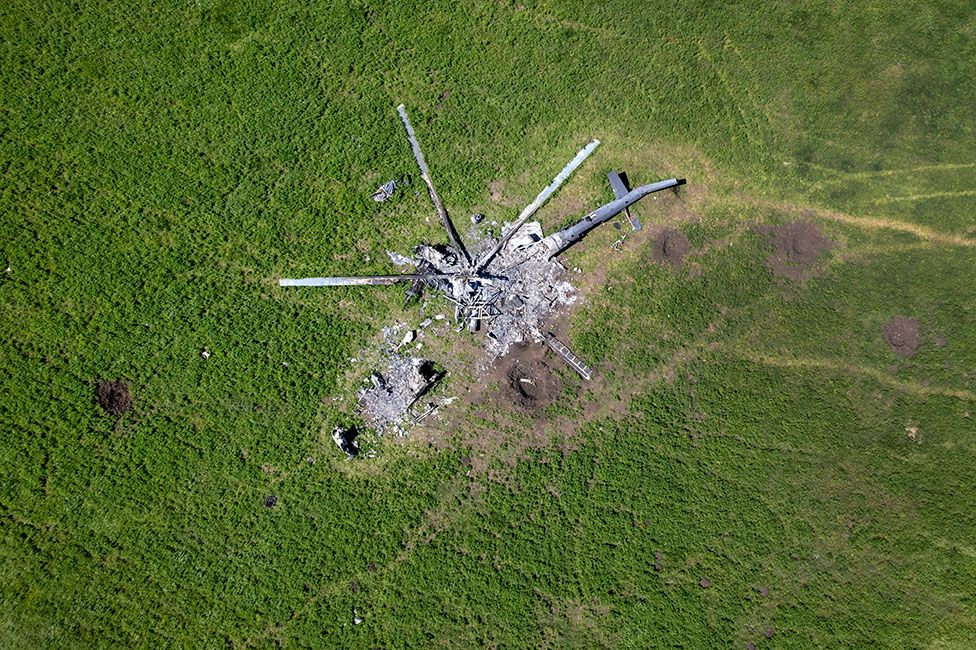 The remains of a Russian helicopter lie in a bomb-cratered field in Biskvitne, Ukraine to the east of Kharkiv