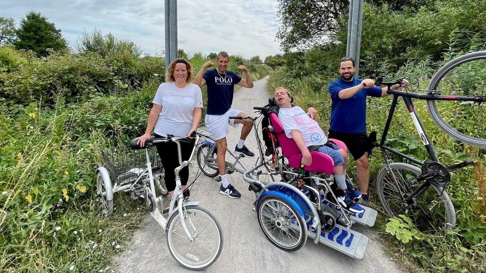 Group photo of four people and bikes