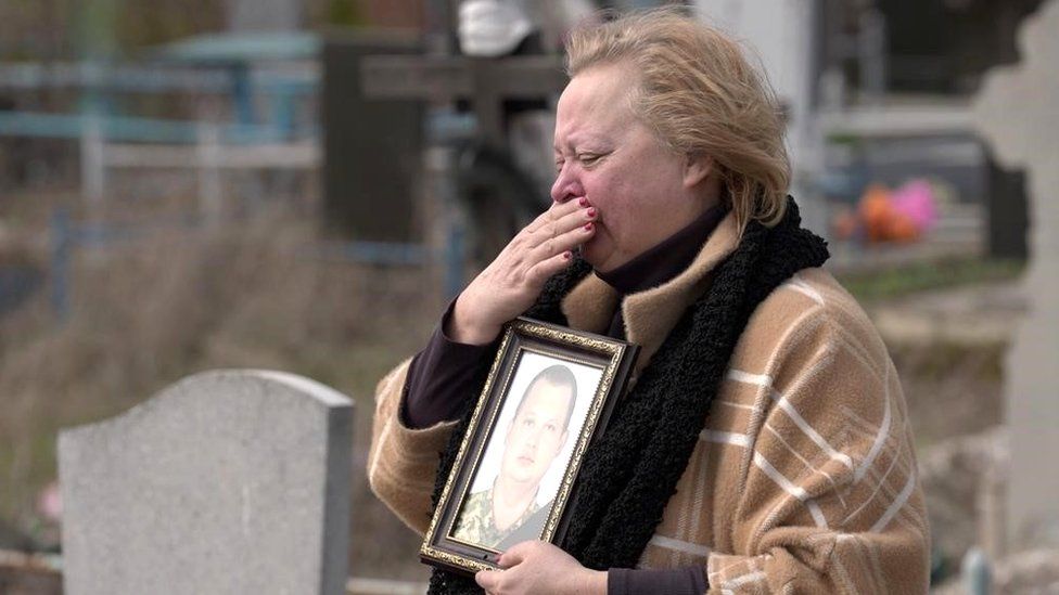 Tatiana clutches a photograph of her son Alexander Tislenko, a 34-year-old killed while fighting with the Ukrainian forces