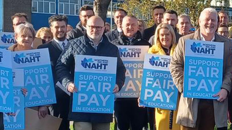 a line of people holding signs for NAHT, a headteachers' union