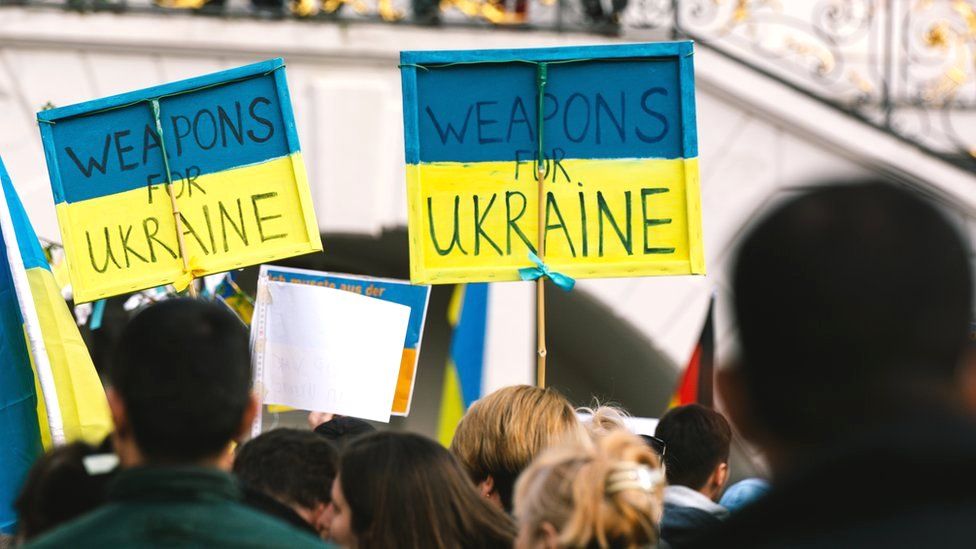 People hold signs that read "weapons for Ukraine" during the anti-war protest in Bonn, Germany, 10 April 2022