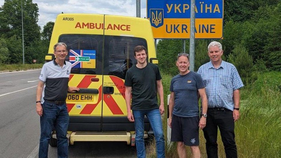 Four men stand at the back of an ambulance at the Ukraine border