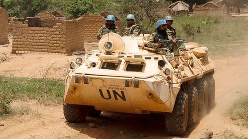 United Nations peacekeeping force vehicles drive by houses destroyed by violence in September, in the abandoned village of Yade, Central African Republic on 27 April 2017