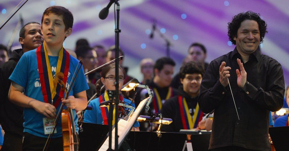 Maestro Gustavo Dudamel applauds as he conducts the children from the Big Noise Orchestra during the Big Concert on 21 June 2012 in Stirling, Scotland