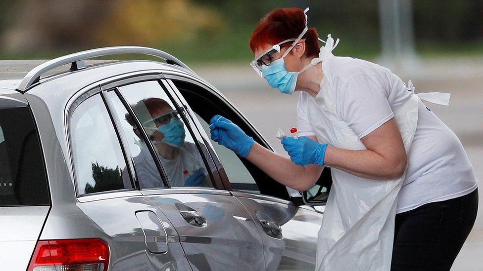 Medical staff at an NHS drive through coronavirus disease (COVID-19) testing facility in the car park of Chessington World of Adventures