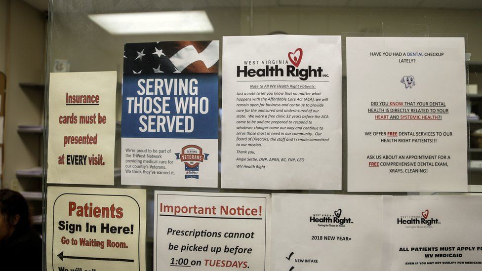 Flyers at front desk of clinic discussing insurance, veterans, affordable care act