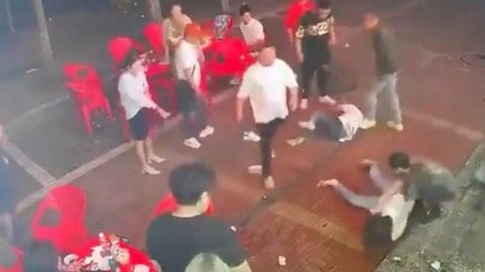 Two women lie on the ground after being assaulted by a group of men outside a restaurant in the northeastern city of Tangshan, China, June 10, 2022, in this screen grab taken from surveillance footage obtained by REUTERS on June 12, 2022.