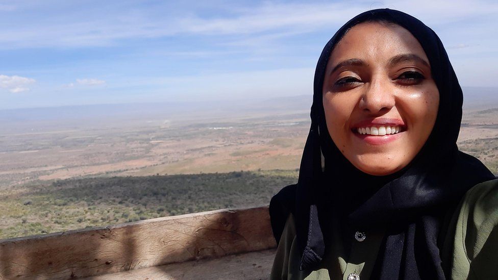 Activist Fazeela Mubarak poses for a photo against a forested backdrop