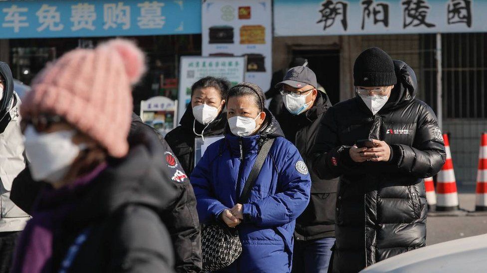 People wearing face masks walk outside a crematorium in Beijing, China, 04 January 2023.