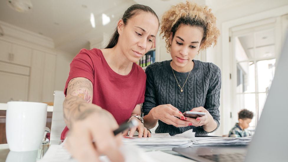 Two women looking at finances at a table