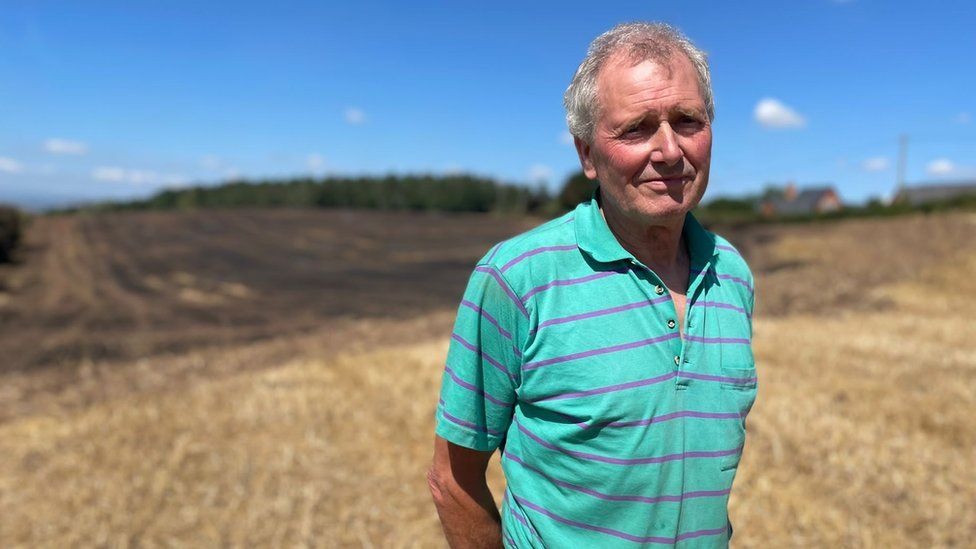 Farmer Edward Freeman in front of burnt fields