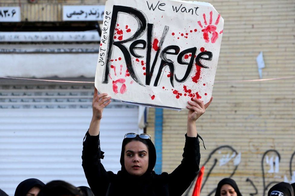 An Iranian protest hold a sign calling for revenge on the US