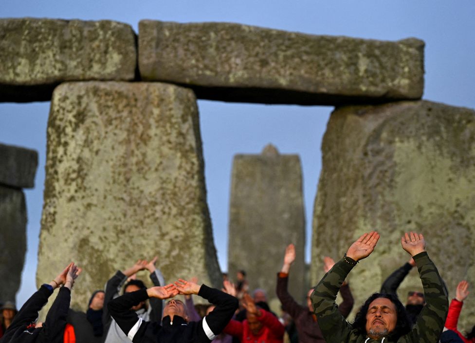 Revellers celebrate the summer solstice at sunrise at Stonehenge stone circle near Amesbury, England.