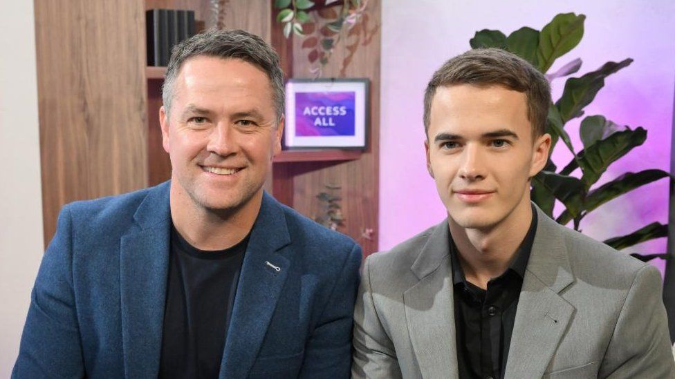 Two men, Michael Owen and son James, sitting side by side in a studio