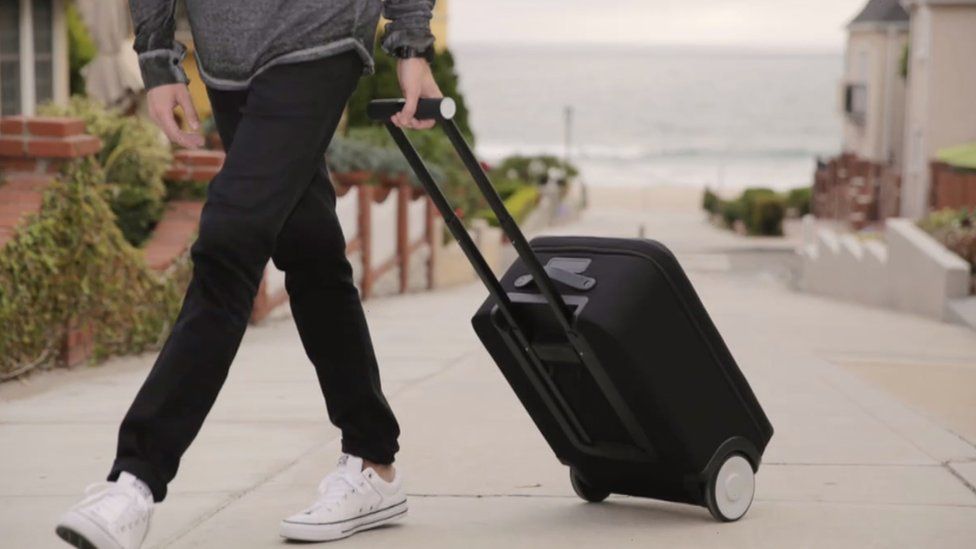 Person wheeling a suitcase