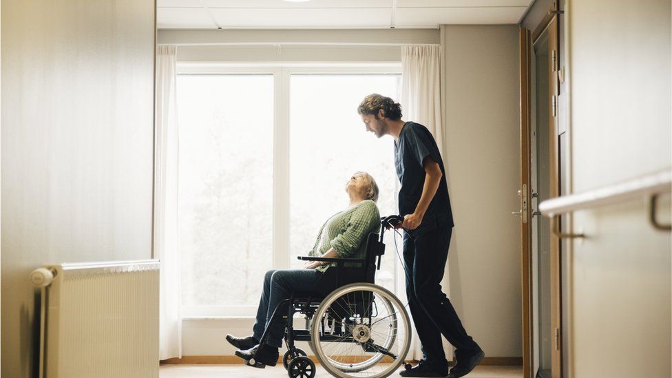 Carer and person in wheelchair