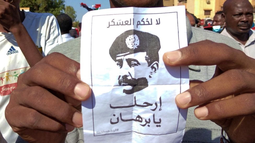 An anti-coup protester in Omdurman holds a poster depicting Sudan's General Abdel Fattah al-Burhan reading: "No to Military Rule" - 17 November 2021