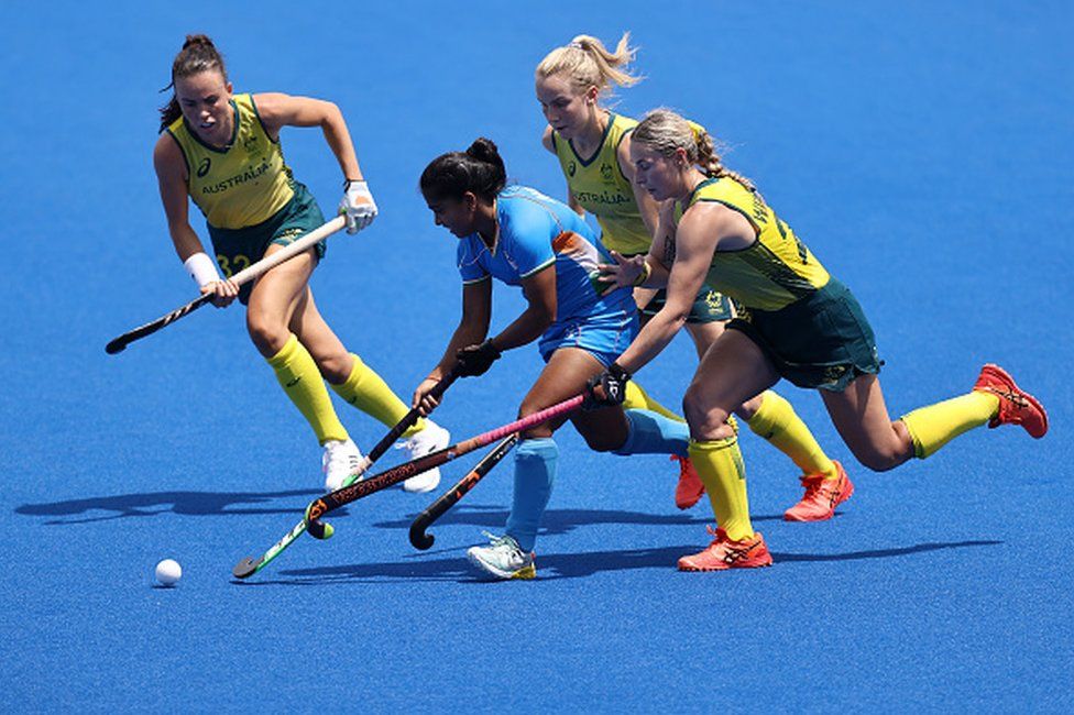 Neha Neha of Team India moves the ball past Mariah Williams and Savannah Fitzpatrick of Team Australia during the Women's Quarterfinal match between Australia and India on day ten of the Tokyo 2020 Olympic Games at Oi Hockey Stadium on August 02, 2021 in Tokyo, Japan