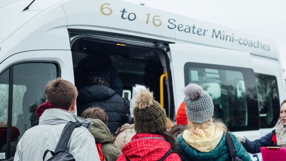 Stock photo of kids boarding a mini bus