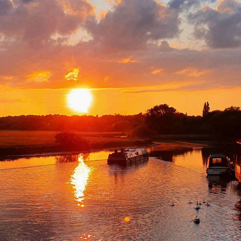 The sun setting over narrowboats in St Ives, Cambridgeshire