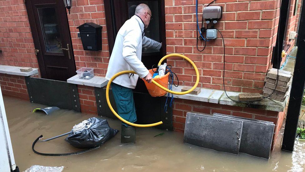Derek Lown trying to salvage his house after the latest flooding in January