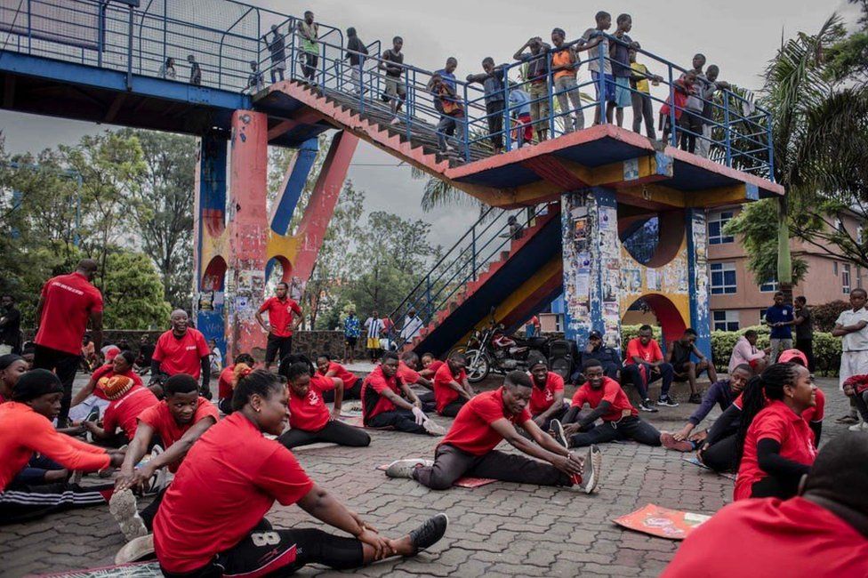 A group of people participate in sports exercises while others look on at a public square in Goma on November 20, 2022