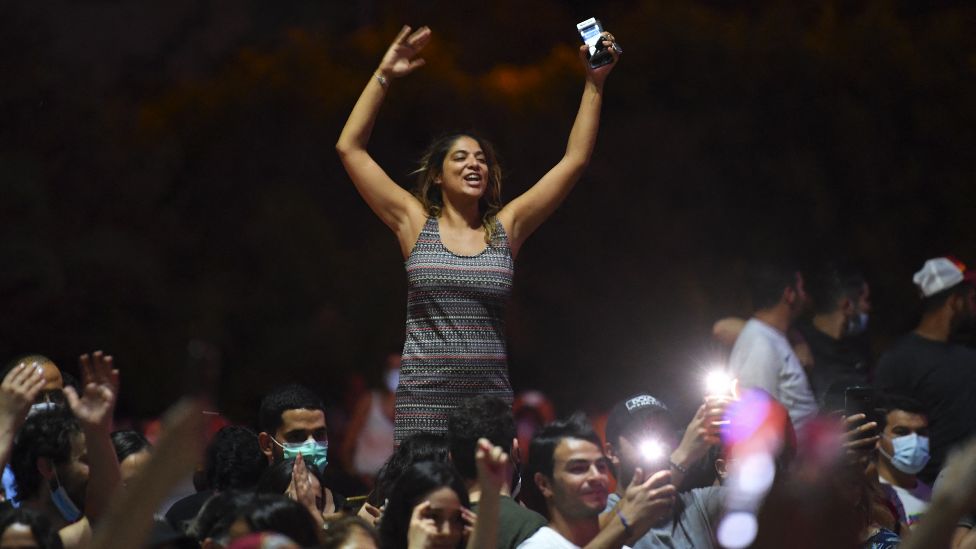 People celebrate in the streets of Tunis after Tunisian President Kais Saied announced the suspension of parliament